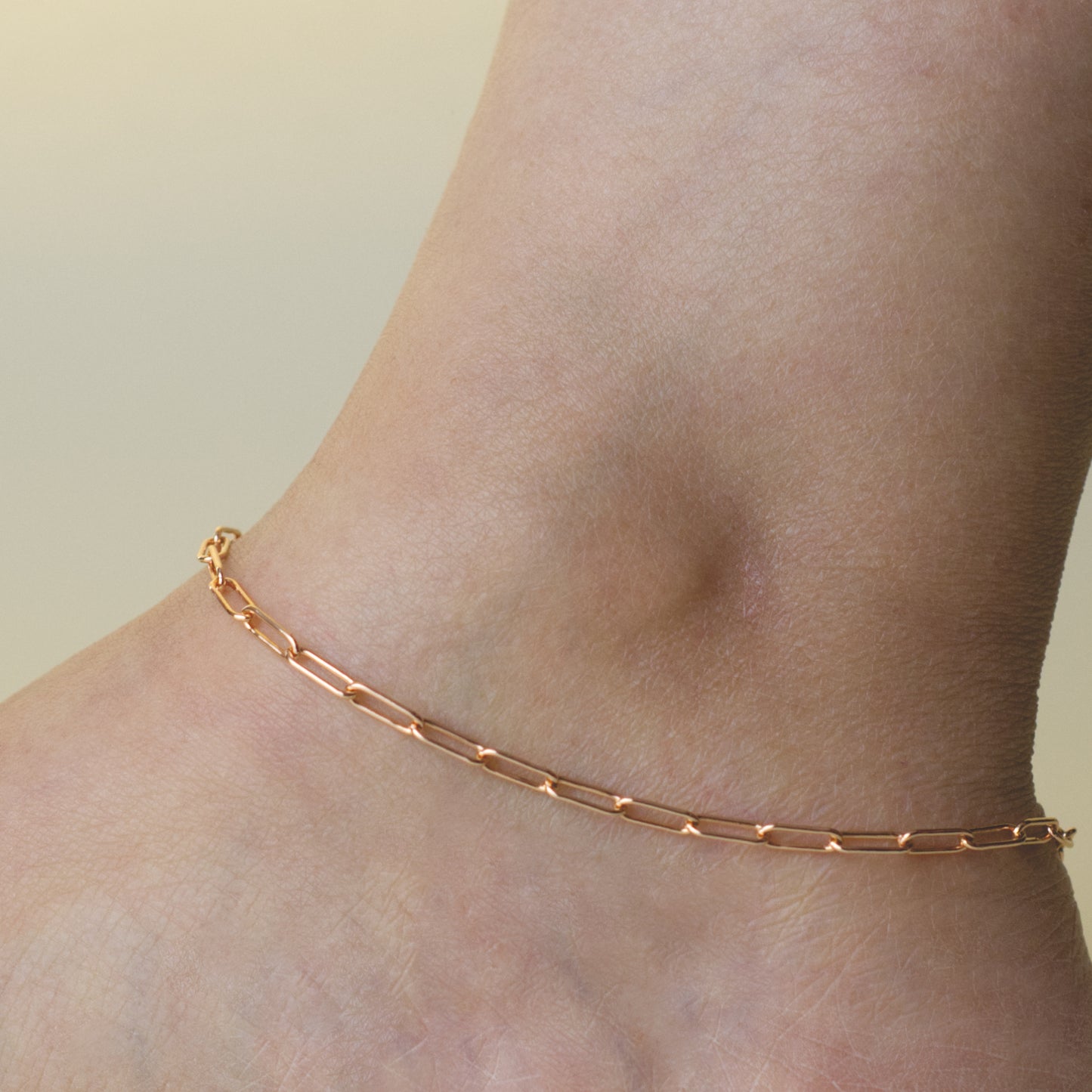 Woman wearing a 14K rose gold fill paperclip chain anklet with a classic style (large) link size
