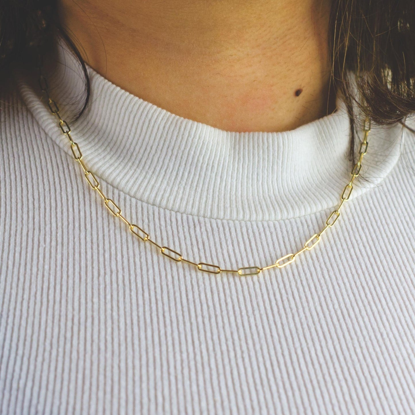 Woman wearing a 14K gold fill paperclip chain necklace with classic style (large) link size
