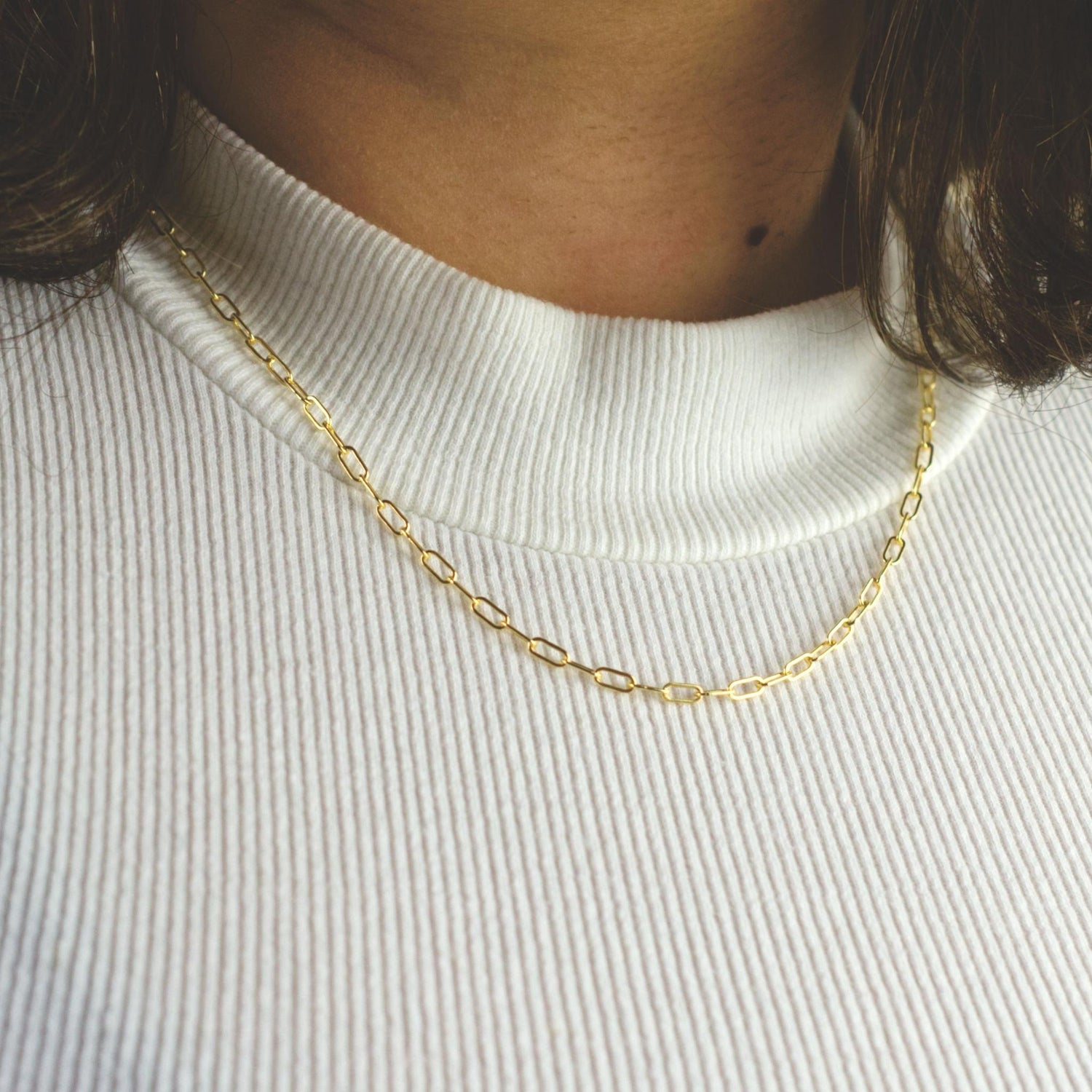 Woman wearing a 14K gold fill paperclip chain necklace with dainty style (medium) link size
