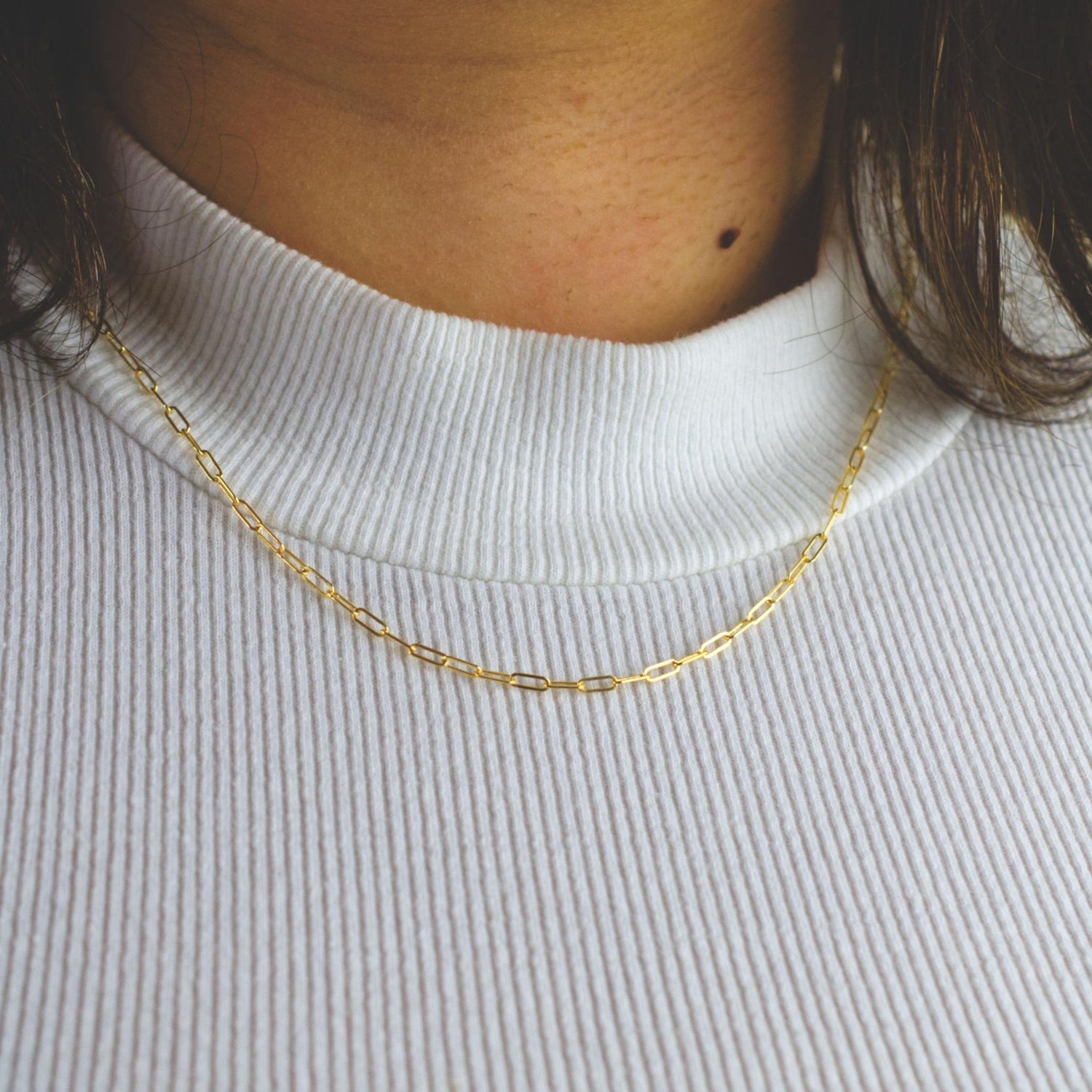 Woman wearing a 14K gold fill paperclip chain necklace with minimalist style (small) link size