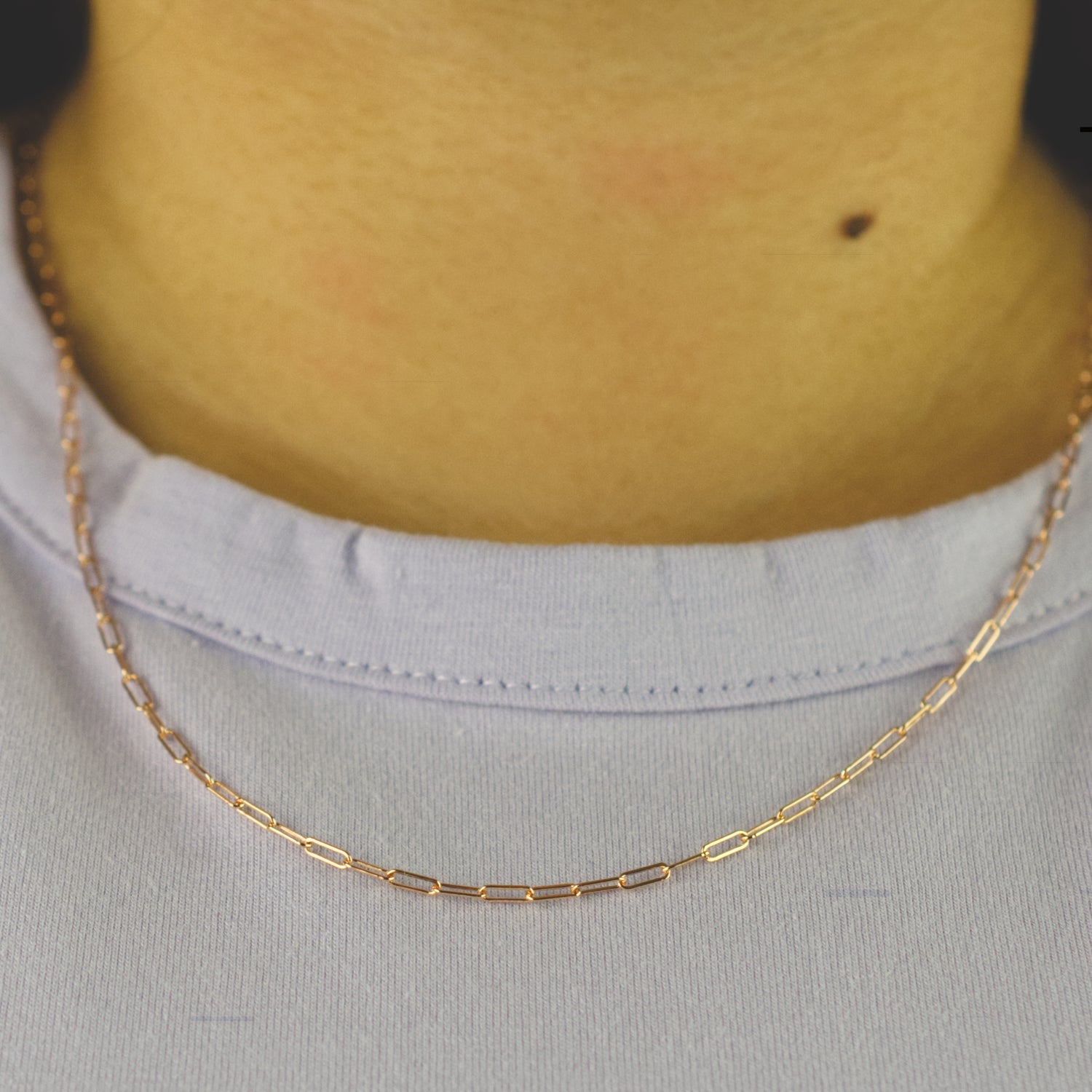 Woman wearing a 14K rose gold fill paperclip chain necklace with minimalist style (small) link size