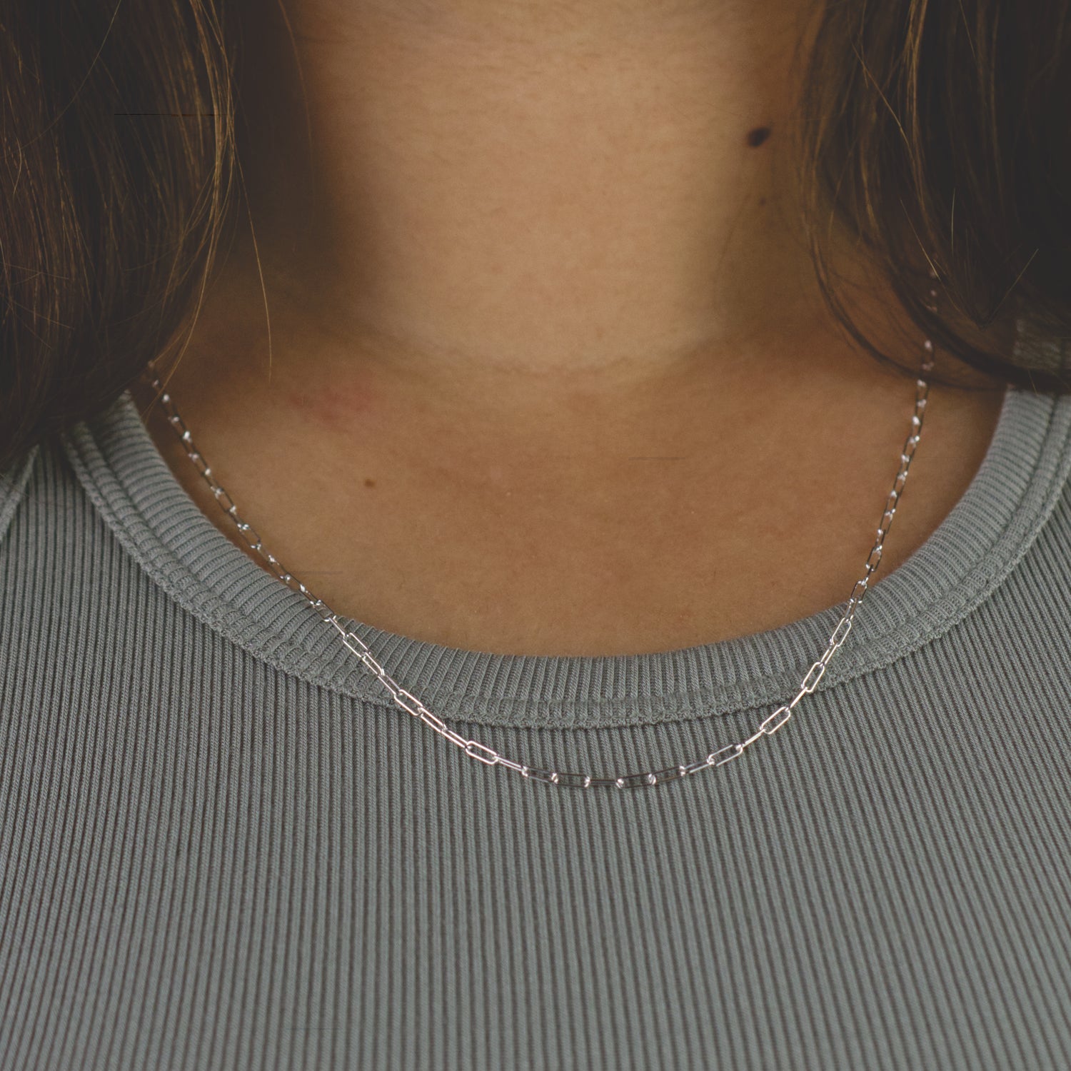 Woman wearing a 925 Sterling Silver paperclip chain necklace with minimalist style (small) link size