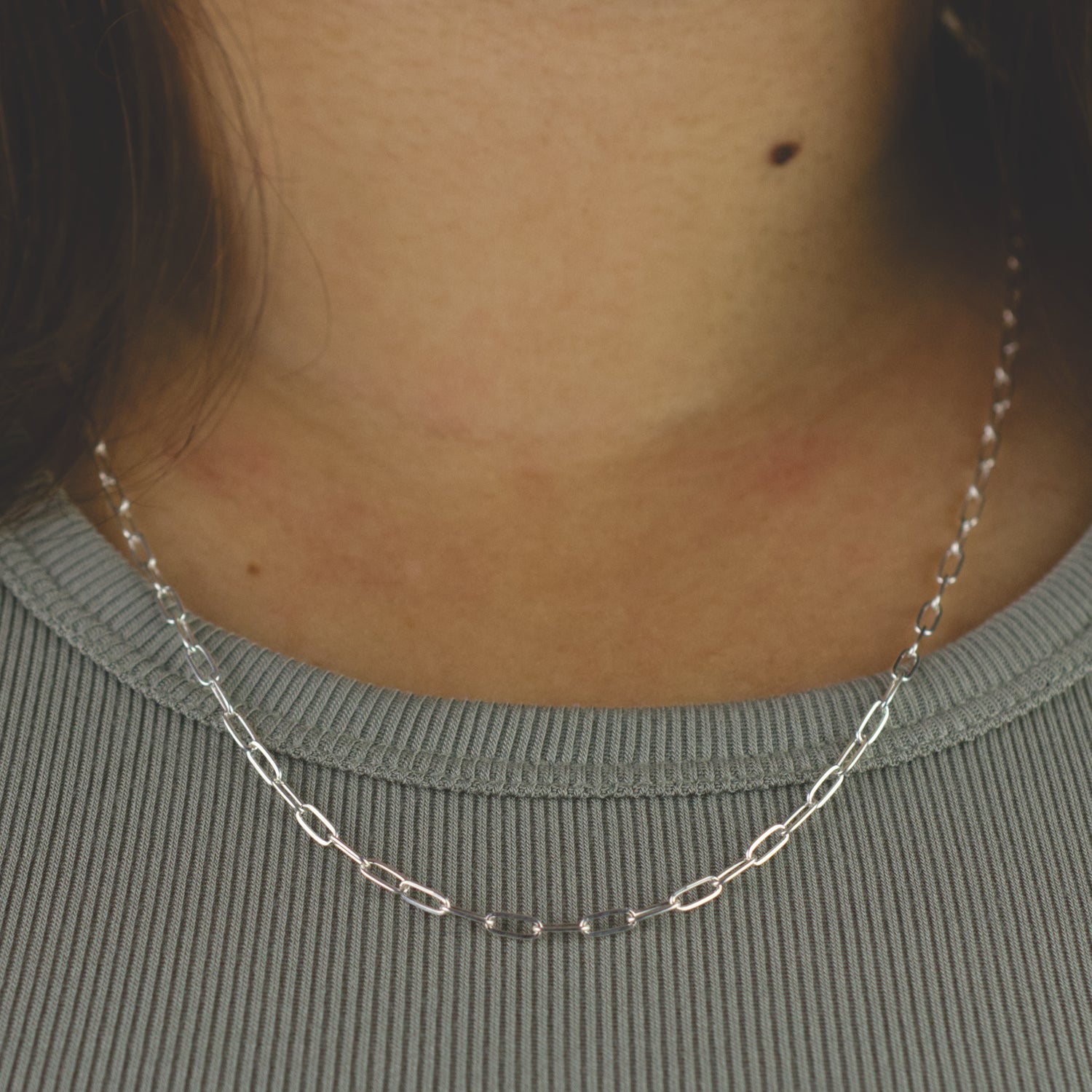 Woman wearing a 925 Sterling Silver paperclip chain necklace with dainty style (medium) link size