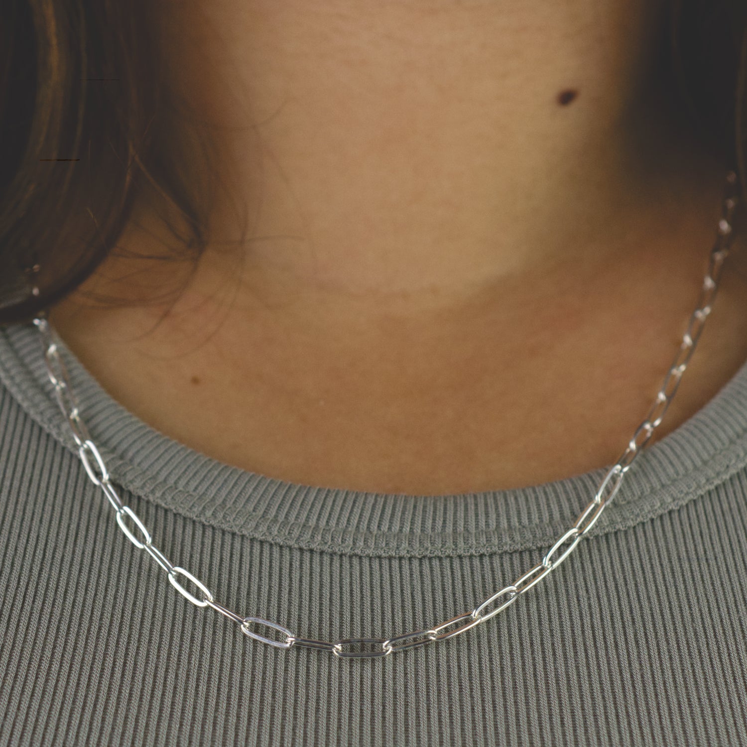 Woman wearing a 925 Sterling Silver paperclip chain necklace with classic style (large) link size