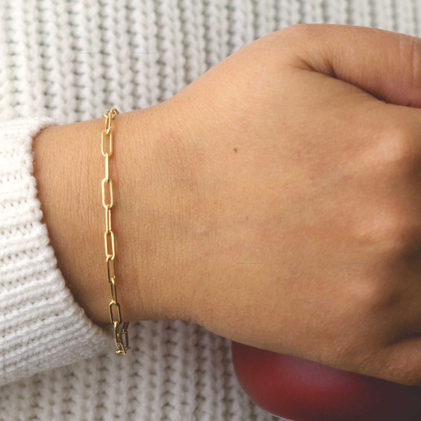Woman wearing a 14K gold fill paperclip chain bracelet with a classic style (large) link size