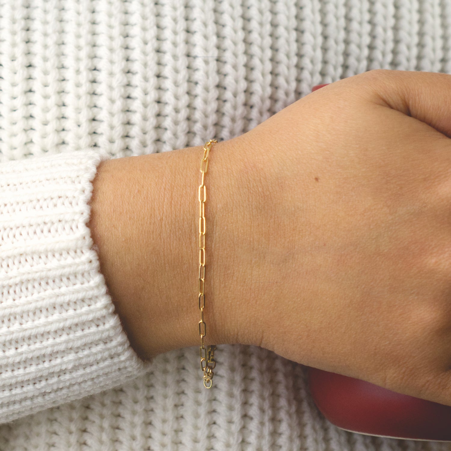 Woman wearing a 14K gold fill paperclip chain bracelet with a minimalist style (small) link size