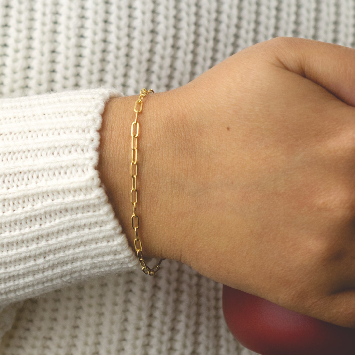 Woman wearing a 14K gold fill paperclip chain bracelet with a dainty style (medium) link size