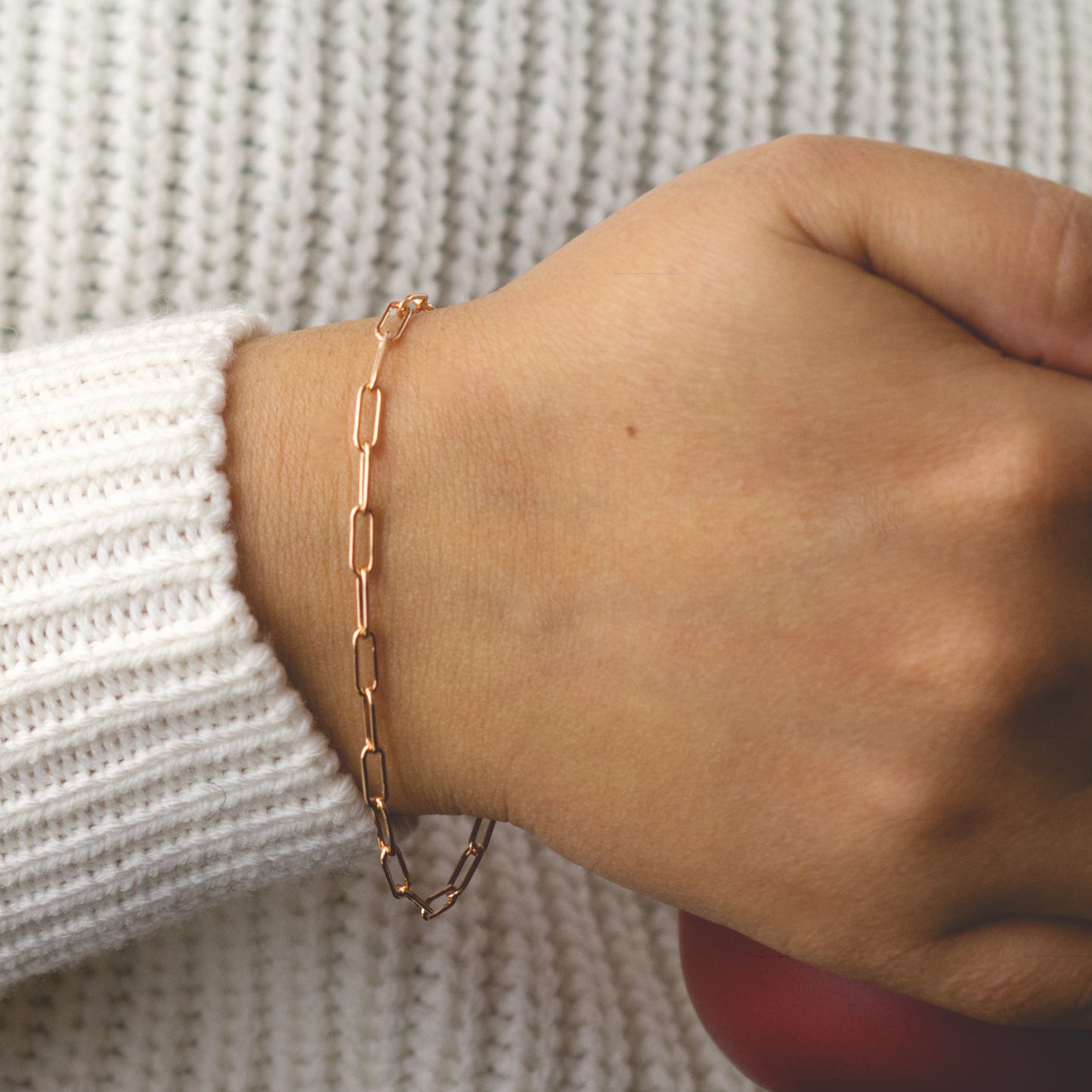 Woman wearing a 14K rose gold fill paperclip chain bracelet with a classic style (large) link size