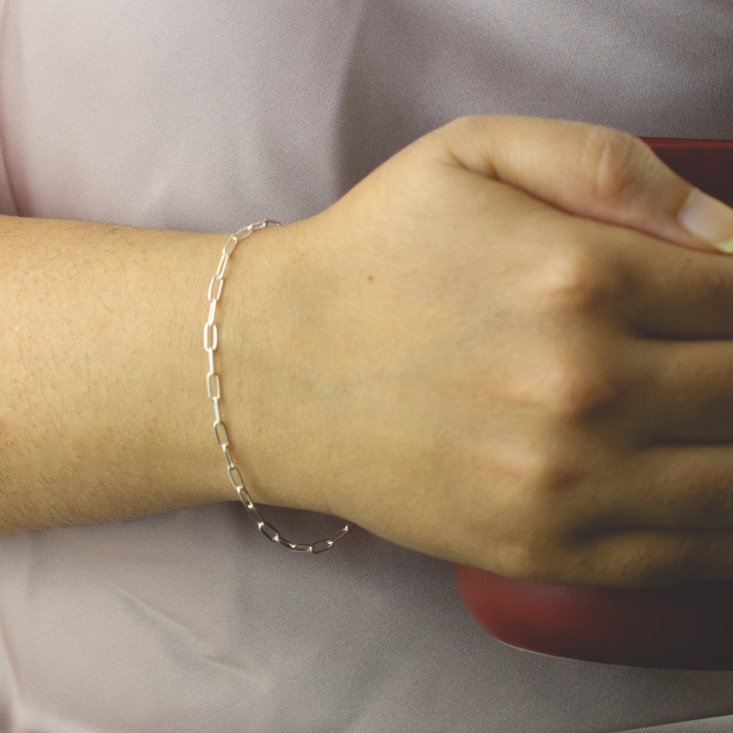 Woman wearing a 925 Sterling Silver paperclip chain bracelet with dainty style (medium) link size