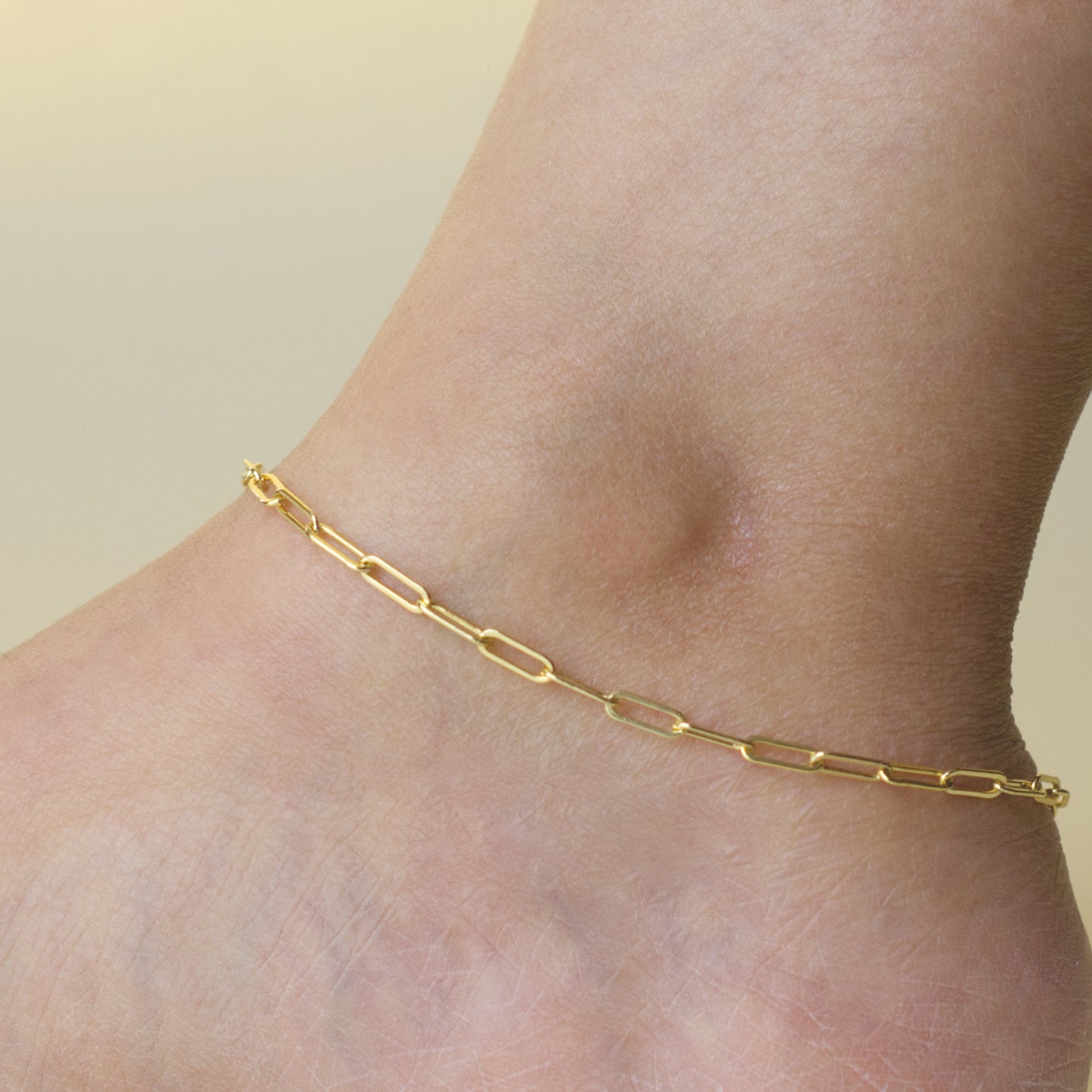 Woman wearing a 14K gold fill paperclip chain anklet with a classic style (large) link size